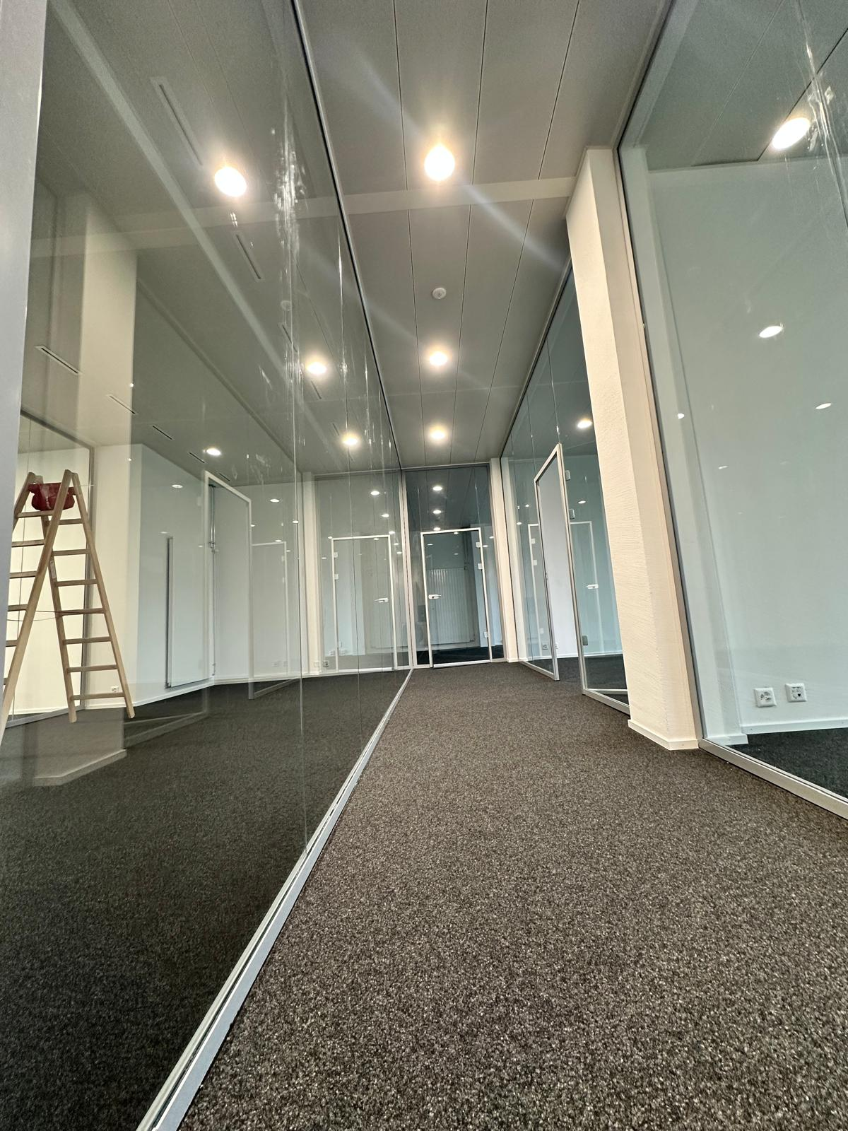 Transparente Glaskonstruktion in einem Korridor