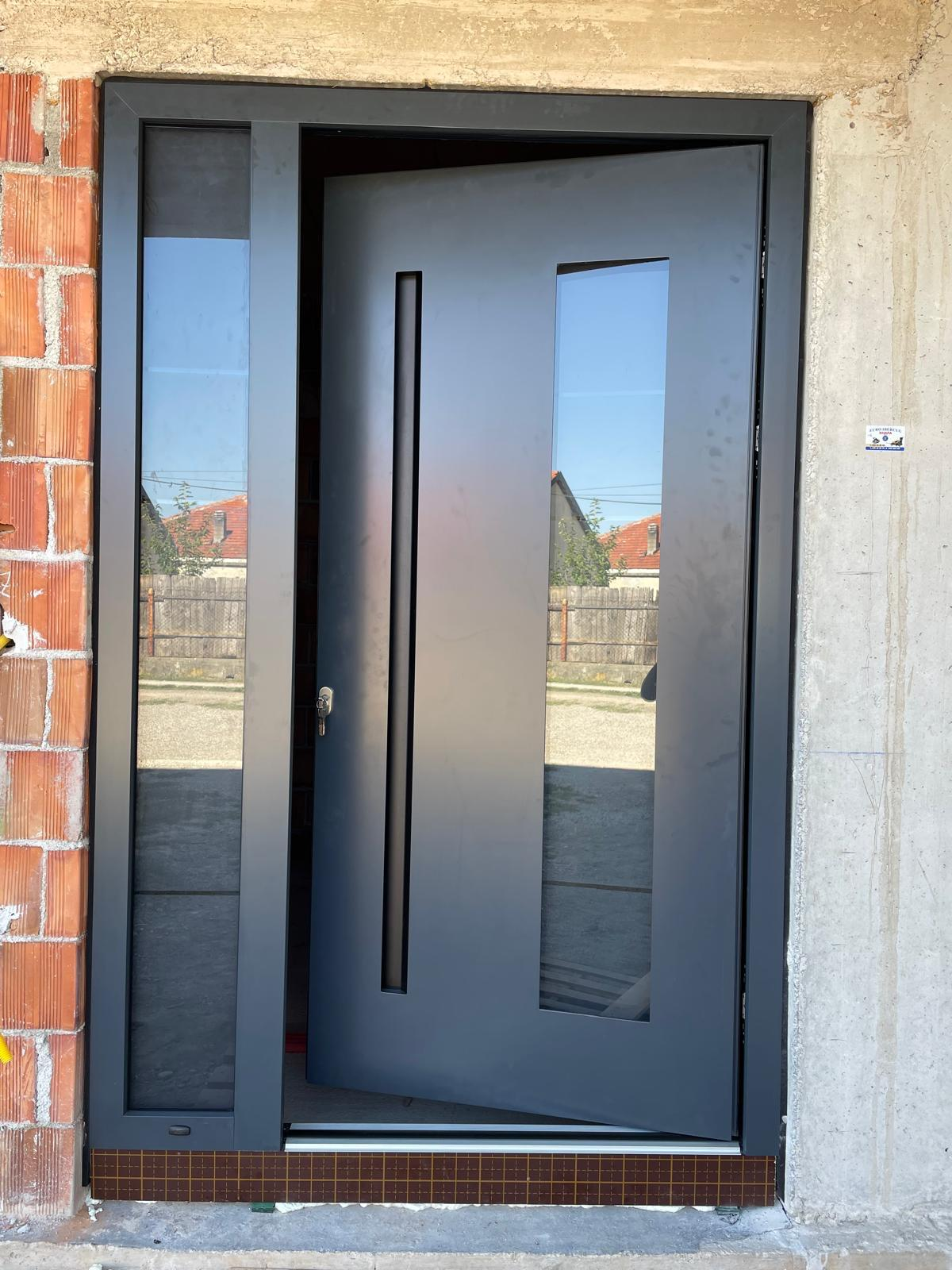 Dunkle Eingangstür mit Glaselementen während der Bauphase